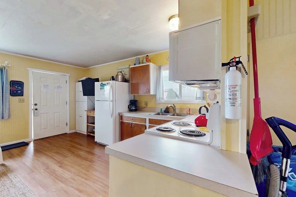 A kitchen with a stove, refrigerator, and cabinets.