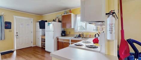 Une cuisine équipée d’une cuisinière, d’un réfrigérateur et de placards.