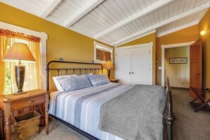 A bedroom with a bed, bedside tables, a lamp, a window with curtains, and a door. - Gorgeous 2BR Soundview - Balcony - Washer Dryer (Lilliwaup)