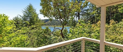 A balcony with a view of a lake and forest.