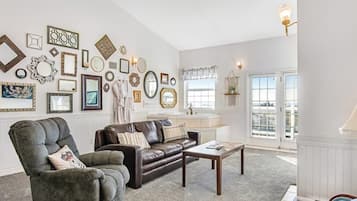 A living room with a brown leather sofa, a grey armchair, and a coffee table.