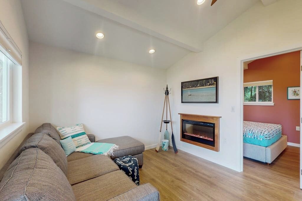 A living room with a sofa, a fireplace, and a painting on the wall.
