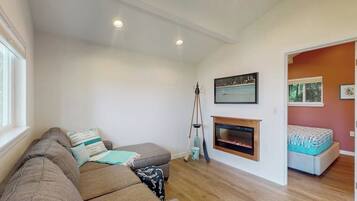 A living room with a sofa, a fireplace, and a painting on the wall.