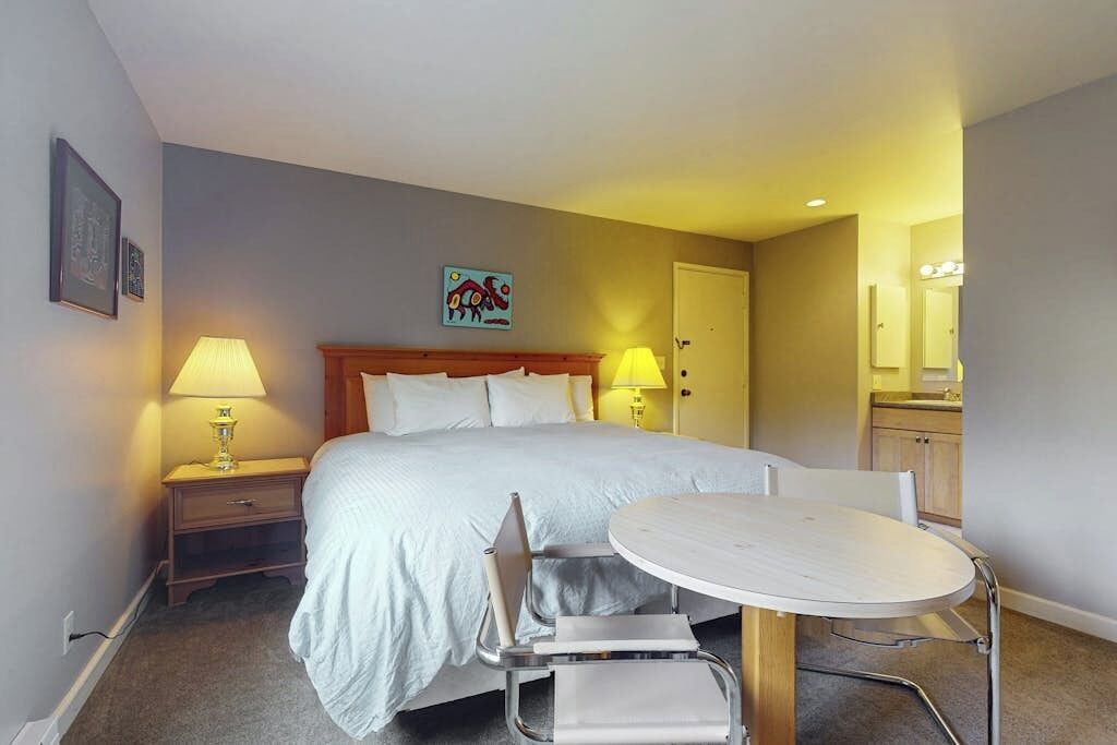 Ein Hotelzimmer mit einem Bett, Nachttischen, einem runden Tisch und Stühlen.
