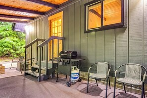 A covered outdoor area with a grill cart, chairs, and a staircase leading to a building. - Alderbrook A-Frame - Game Room - Fireplace - Deck (Union)