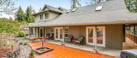 A house with a covered patio, outdoor seating, and a barbecue grill.
