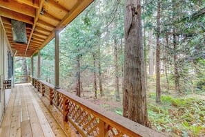 Eine Holzterrasse mit Geländer, mit Blick auf ein bewaldetes Gebiet.