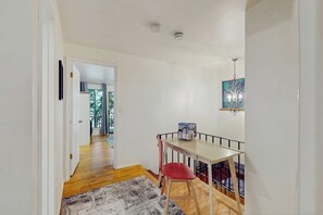 A narrow hallway with a wooden floor, a white wall, and a door leading to another room. - 3BR Home on the Hood Canal with beach access & views (Poulsbo)