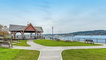A waterfront park with a gazebo, benches, and a walking path.