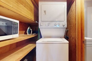 Een kleine keuken met een magnetron, een kookplaat en een spoelbak.