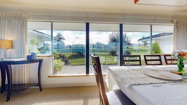 A bedroom with a large window, a bed, a desk, and a chair. - 4BR Home with bay and mountain views, beach access (Sequim)