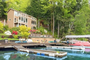 A waterfront property with a dock, boats, and a building with balconies. - 1BR lakefront townhouse with dock, 2 kayaks, grill (Port Angeles)