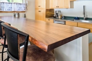 A kitchen with a wooden countertop, a chair, and cabinets. - 1BR lakefront townhouse with dock, 2 kayaks, grill (Port Angeles)