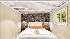 Een slaapkamer met een bed, een raam en behang met een patroon.