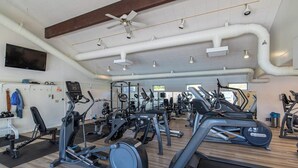 A gym with various exercise equipment, a ceiling fan, and a TV mounted on the wall. - 2 BR condo with stunning water views (Port Ludlow)