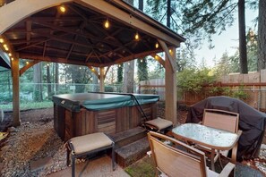 An outdoor patio with a hot tub, seating, and a grill. - Charming 3BR - Hot Tub - Gas Grill - Dogs-OK (Port Orchard)