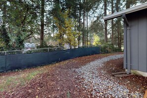 A gravel path leading to a building with a metal roof, surrounded by a fence and trees. - Charming 3BR - Hot Tub - Gas Grill - Dogs-OK (Port Orchard)