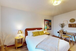 A bedroom with a bed, bedside tables, a desk, and a chair. - 1BR  with loft retreat with wrap around balcony & Washer Dryer (Westport)