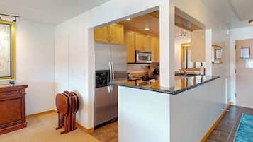 A modern kitchen with a central island, stainless steel appliances, and wooden cabinetry.