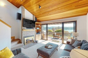 Een moderne woonkamer met een open haard, een televisie en een balkon met uitzicht.