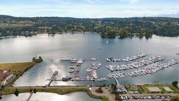 A marina with boats docked, a parking area, and a bridge connecting to the land.