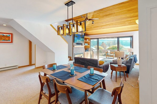 A modern interior with a dining area, a staircase, and a view of the outdoors.