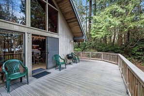 A wooden deck with outdoor seating and a building with large windows. - Dreamy 2BR Dog Friendly - Pool - Hot Tub - Dock (Shelton)