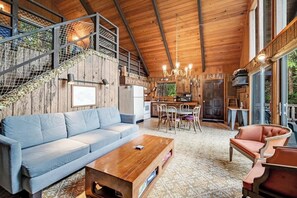 Ein Holzinterieur mit einer Couch, einem Couchtisch und einem Essbereich.