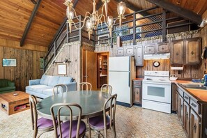 A rustic interior with a dining area, kitchen, and staircase. - Dreamy 2BR Dog Friendly - Pool - Hot Tub - Dock (Shelton)