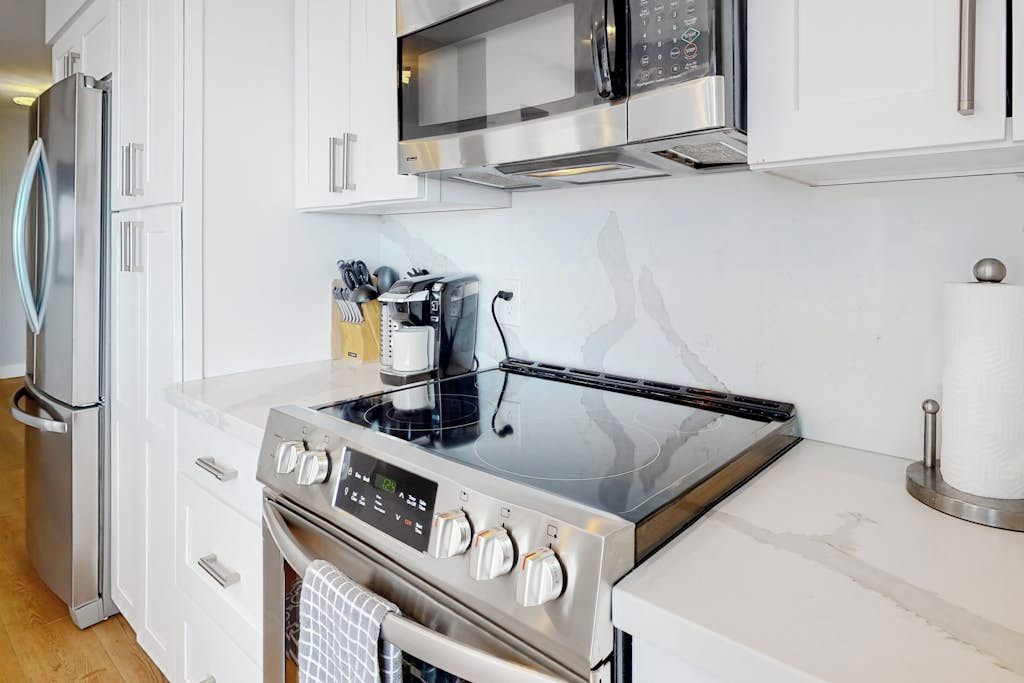 Una cocina moderna con electrodomésticos de acero inoxidable, incluyendo estufa, horno y microondas.