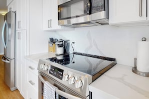 A modern kitchen with stainless steel appliances, including a stove, oven, and microwave. - 2BR condo with water view, full kitchen, Washer Dryer (Seattle)
