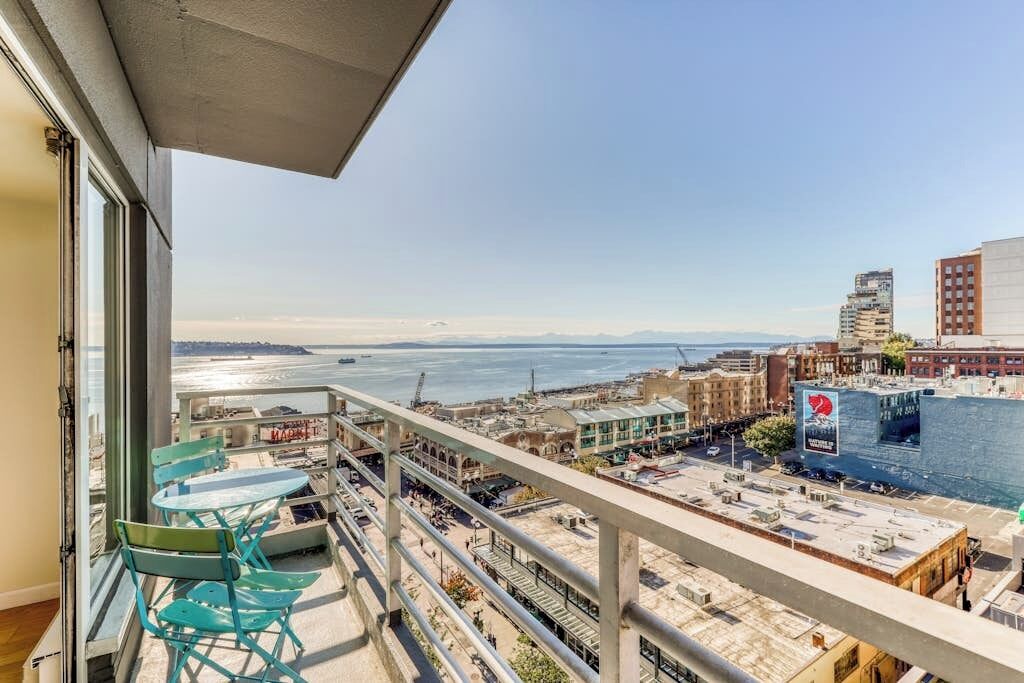 A balcony with a view of a cityscape and a body of water.