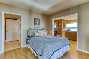 A bedroom with a bed, a painting, and a view to the outside. - Dog-friendly, bay view suite with walk score of 100 (Seattle)