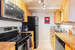 A compact kitchen with a microwave, stove, refrigerator, and dishwasher. - Luxe 1BR with huge bay view, pool, & hot tub (Seattle)