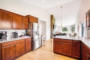 A spacious kitchen with wooden cabinets, stainless steel appliances, and a large island. - Lovely 2BR Mountainview - Deck - Firepit - Washer Dryer (Cle Elum)