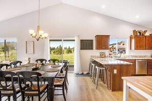 A spacious dining area with a high ceiling and a view of the outdoors. - Lovely 2BR Mountainview - Deck - Firepit - Washer Dryer (Cle Elum)