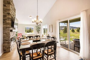 Un espace repas comprenant une grande table, des chaises et un lustre.