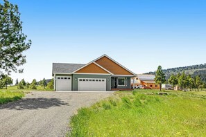Ein zweistöckiges Haus mit Garage, Auffahrt und Rasengrundstück.