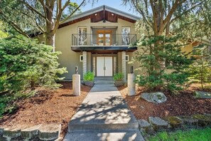A two-story house with a balcony, a front door, and a pathway leading to the entrance. - 4BR home with pool, hot tub & great location (Tacoma)