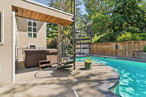A backyard with a swimming pool, a hot tub, and a wooden deck. - 4BR home with pool, hot tub & great location (Tacoma)