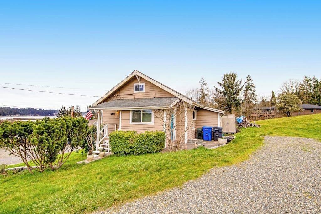 A single-story house with a sloped roof, a front porch, and a small front yard.