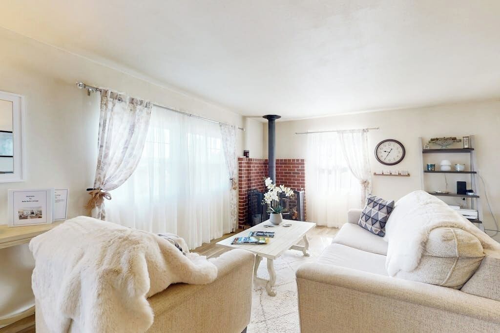 A cozy living room with a fireplace, a sofa, a coffee table, and a bookshelf.