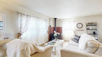 A cozy living room with a fireplace, a sofa, a coffee table, and a bookshelf.