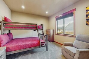 A bunk bed room with a desk and chair, a window with a view, and a sofa. - 3BR home with hot tub, pool table & wifi (Ronald)