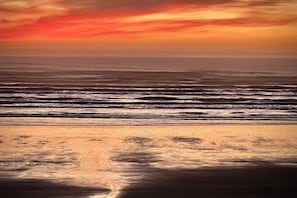 Een strand met golven en een zonsondergang.