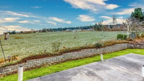 Een grasveld met een stenen muur en een verhard gebied op de voorgrond.