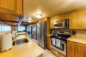 A kitchen with wooden cabinets, stainless steel appliances, and a tiled backsplash. - 2BR waterfront home with full kitchen & deck views (Poulsbo)