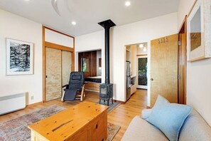 Ein modernes Wohnzimmer mit einer Couch, einem Holztisch, einem schwarzen Sessel und einem Kamin.