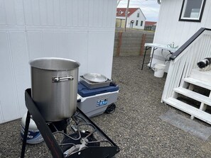 A portable gas stove with a pot and a container, a white outdoor bench, and a dog on the steps. - 1BR Home in the Historic Marina District -1 dog ok (Westport)