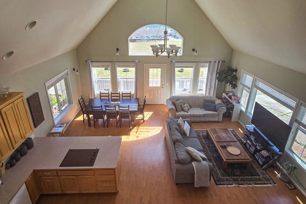 A spacious living area with a dining table, sofa, and TV.